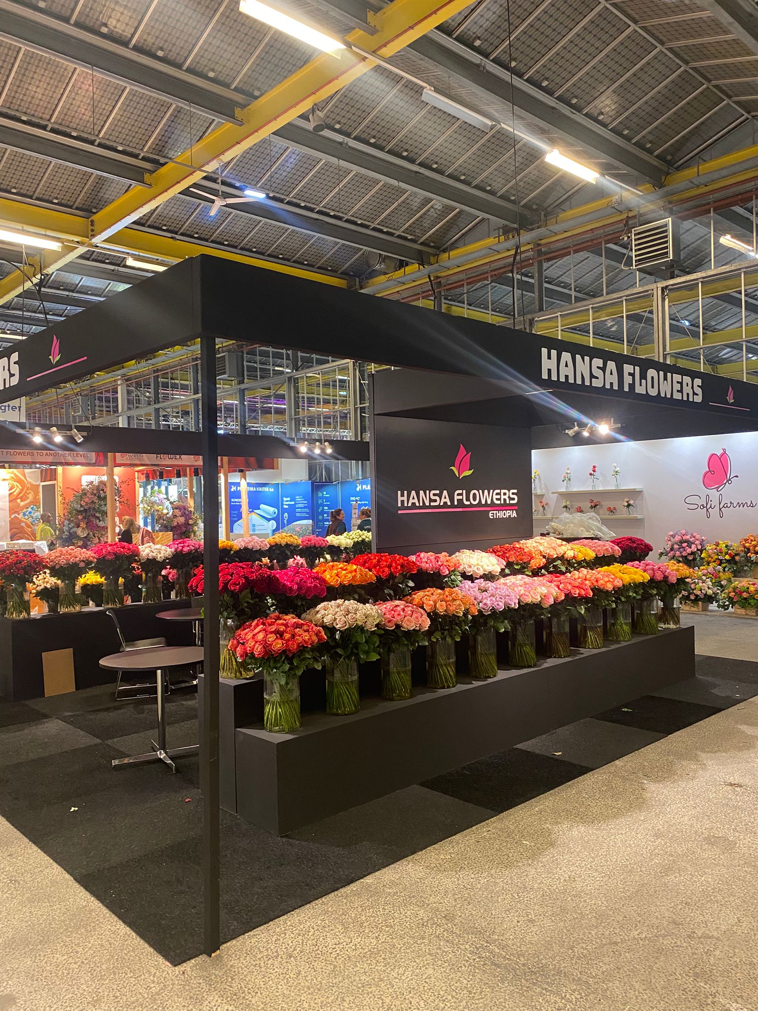 Beursstand met bloemen en witte balie